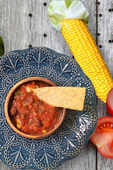 Fresh Salsa in a bowl with vegetables around it