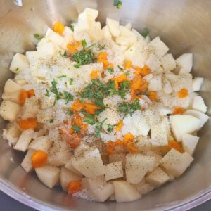 Potatoes, carrots, onion, and seasonings in a pot