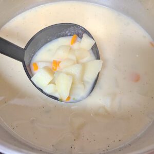 Soup fully cooked in pot with ladle of soup