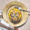 Sausage and Apple Stuffed Acorn Squash on plate with fork and napkin