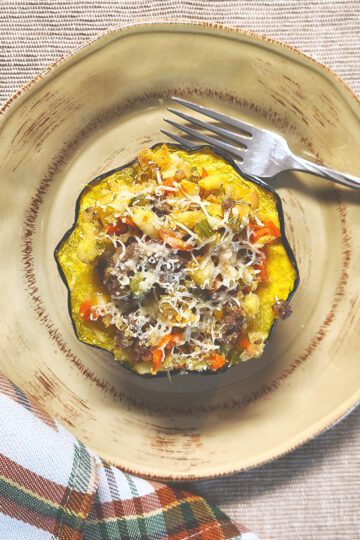 Sausage and Apple Stuffed Acorn Squash on plate with fork and napkin