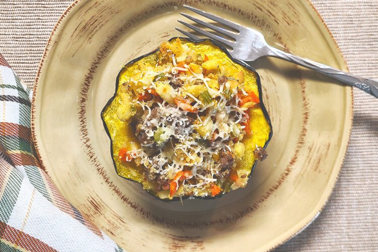 Sausage and Apple Stuffed Acorn Squash on plate with fork and napkin