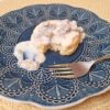 Sausage gravy over biscuit on a blue plate