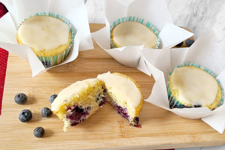 Lemon Blueberry Mini-Cakes on a wooden cutting board with a red cloth napkin underneath
