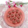 Peanut butter filled chocolates on round plate with towel and flowers around
