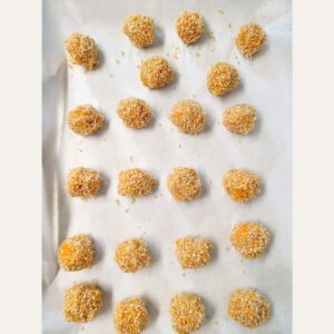 savory sweet potato balls on baking sheet with parmchment paper