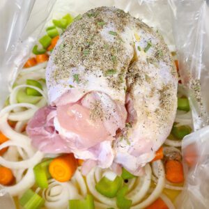 turkey breast on top of veggies in oven roasting bag