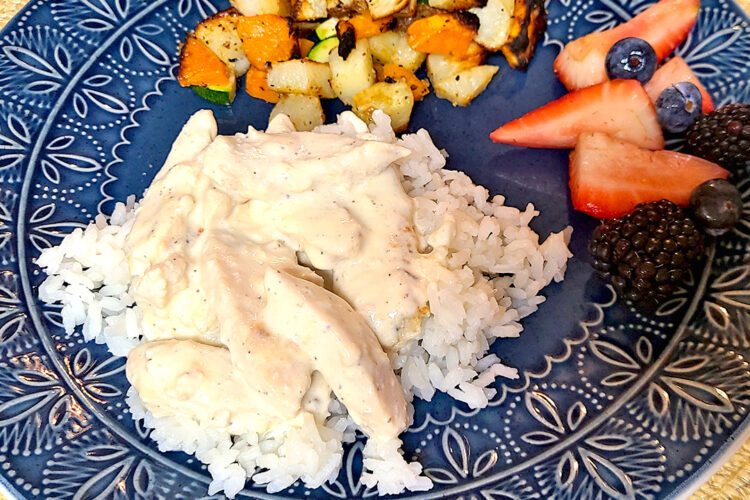 Lemon Pepper Chicken on rice with berries and roasted veggies on a blue plate