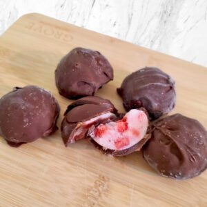 chocolate covered strawberry yogurt bites on a wood board