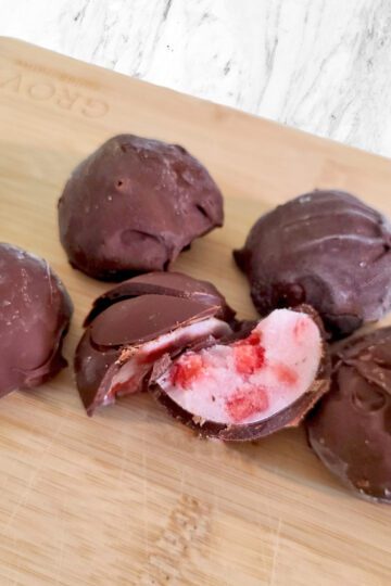 chocolate covered strawberry yogurt bites on a wood board