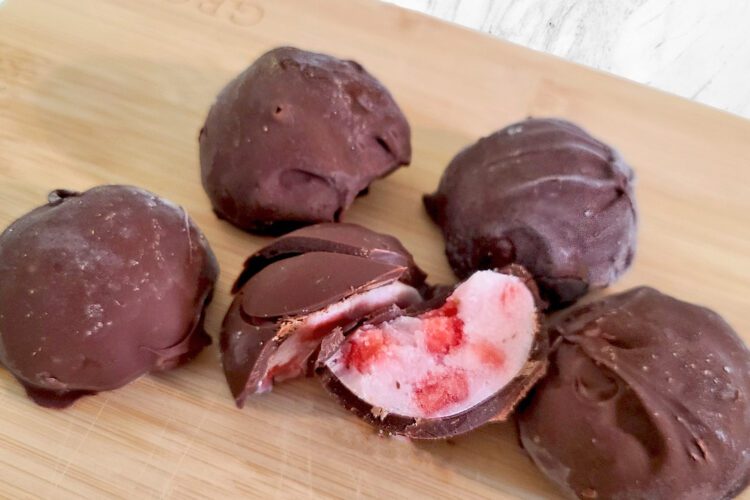 chocolate covered strawberry yogurt bites on a wood board