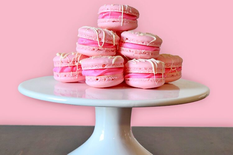 strawberry macaroons on white cake stand with pink and brown background