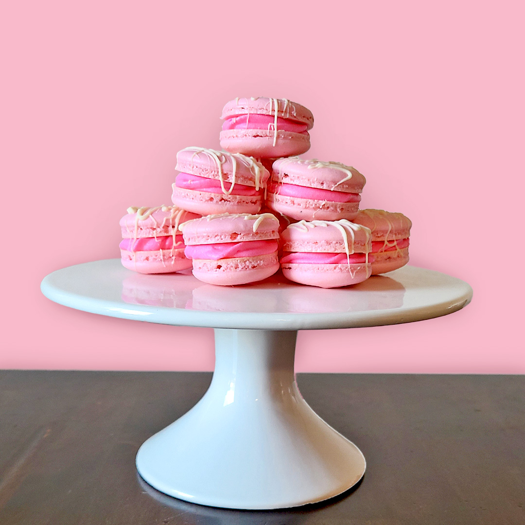 strawberry macaroons on white cake stand with pink and brown background