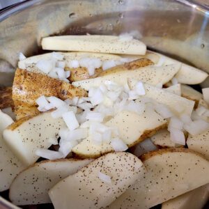potato wedges in instant pot with diced onions on top