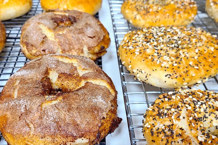 gluten free bagels on a cooling rack; cinnamon sugar, plain, and everything bagel
