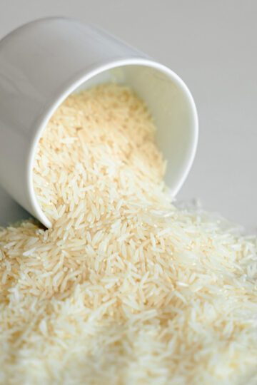 Rice falling out of a white bowl onto counter