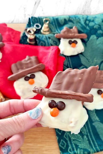Gluten Free Pretzels made into snowman with white and dark chocolate with mini m&m's for the eyes and nose