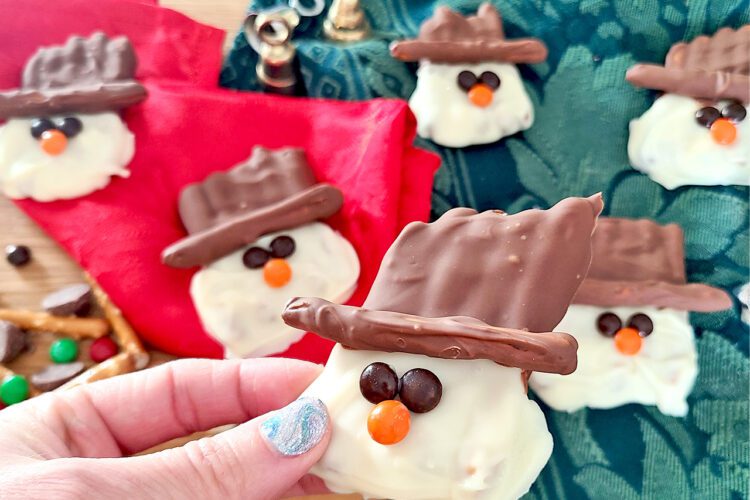 Gluten Free Pretzels made into snowman with white and dark chocolate with mini m&m's for the eyes and nose
