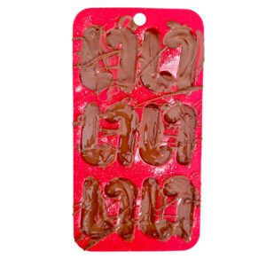 milk chocolate poured on top of smashed peppermint candy canes in a silicone mold with candy candy shapes