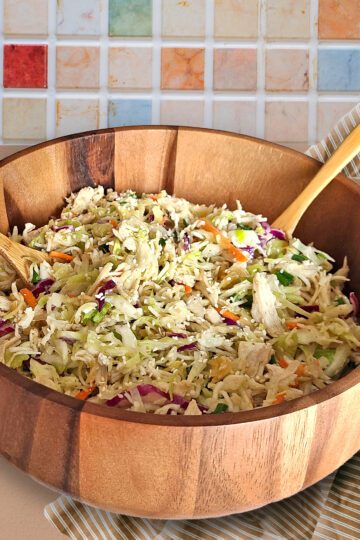 Gluten free chicken cabbage salad in a wooden bowl on counter