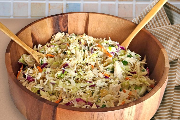 Gluten free chicken cabbage salad in a wooden bowl on counter