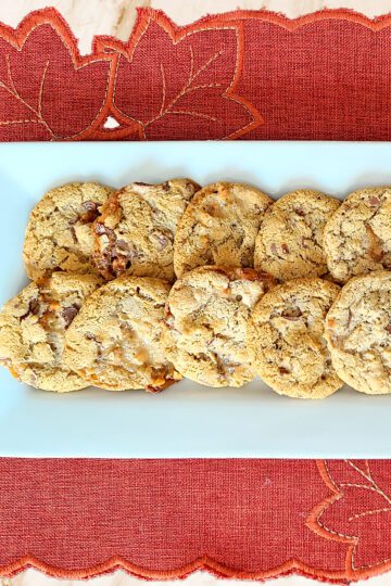 Gluten Free Snickers Cookies on a white platter with a rusty orange placemat underneath