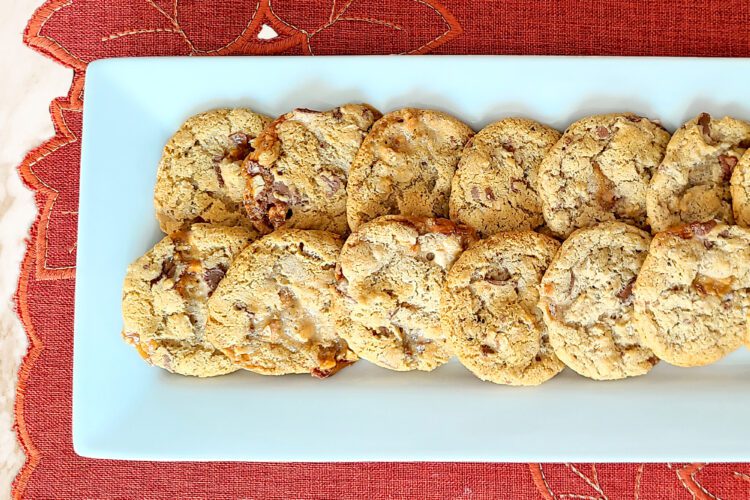 Gluten Free Snickers Cookies on a white platter with a rusty orange placemat underneath