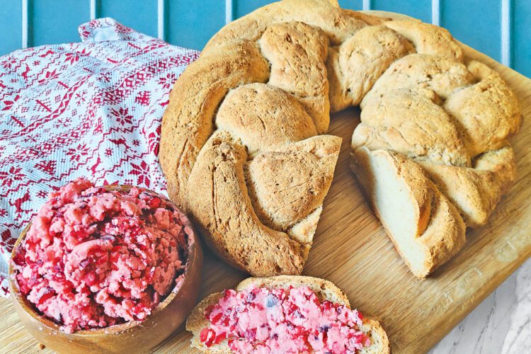 Braided Gluten Free Bread on a wooden cutting board with cranberry honey butter