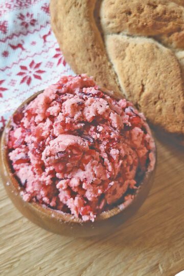 Cranberry Honey Butter in a small wooden bowl next to a loaf of gluten free bread