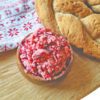 Cranberry Honey Butter in a small wooden bowl next to a loaf of gluten free bread