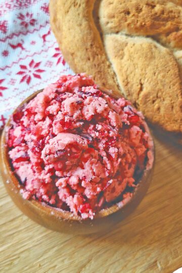 Cranberry Honey Butter in a small wooden bowl next to a loaf of gluten free bread