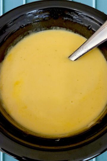 Homemade gluten free cheese dip in a small black crockpot