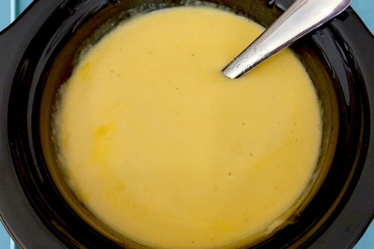 Homemade gluten free cheese dip in a small black crockpot